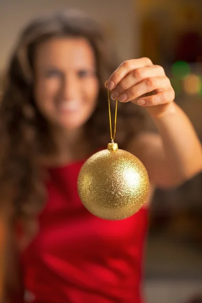 Primer plano de feliz joven ama de casa mostrando la bola de Navidad —  Fotos de Stock