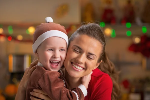 Portret van gelukkige moeder en baby knuffelen in Kerstmis ingericht — Stockfoto