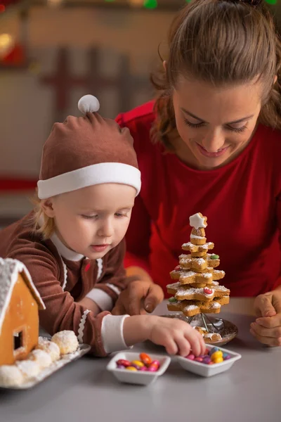 Lycklig mor och barn att göra cookie julgran — Stockfoto