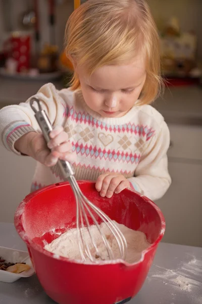 Bebê batendo farinha na cozinha — Fotografia de Stock