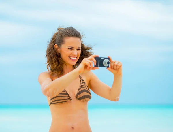 Mladá žena brát fotografie na pláži — Stock fotografie
