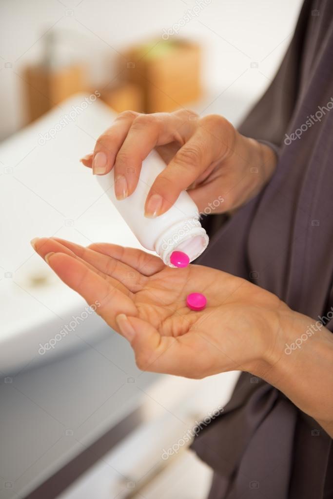 Closeup on young woman with pills