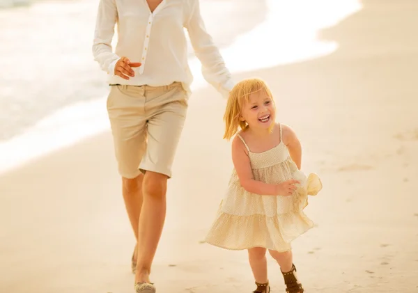 Mor og baby pige kører på stranden om aftenen - Stock-foto