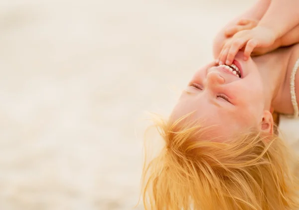 Portret van glimlachende babymeisje op het strand in de avond — Stockfoto