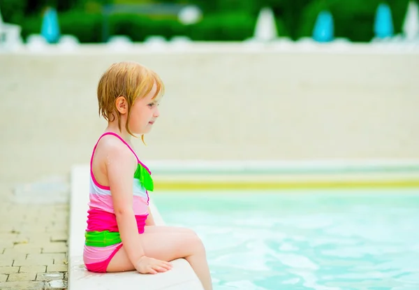Baby girl sitting near swimming pool — Stock Photo, Image