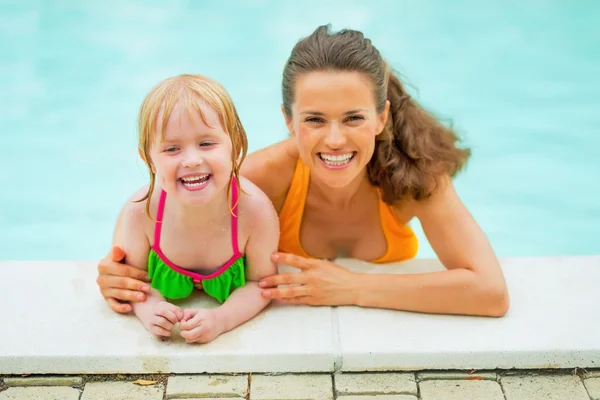 Porträtt av leende mor och baby flicka i poolen — Stockfoto