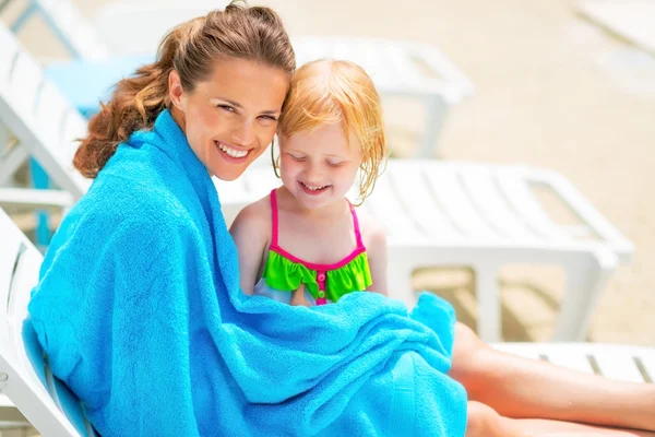 Portrait of happy mother and baby girl wrapped in towel sitting — Stock Photo, Image