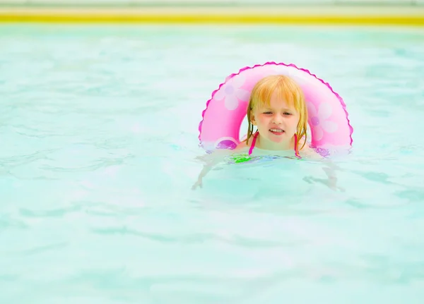 Bébé fille avec anneau de natation dans la piscine — Photo