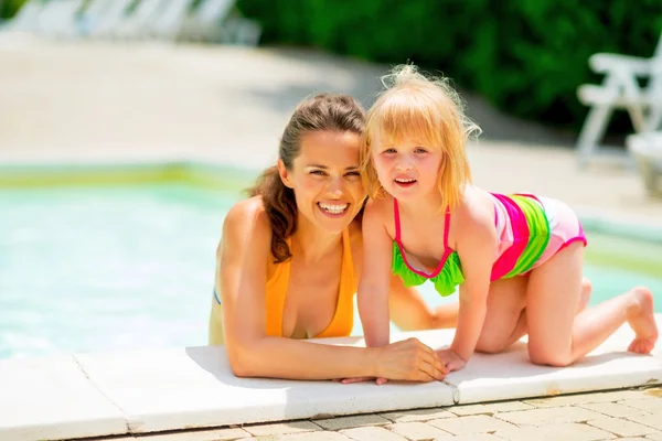 Porträt einer lächelnden Mutter und eines kleinen Mädchens im Schwimmbad — Stockfoto