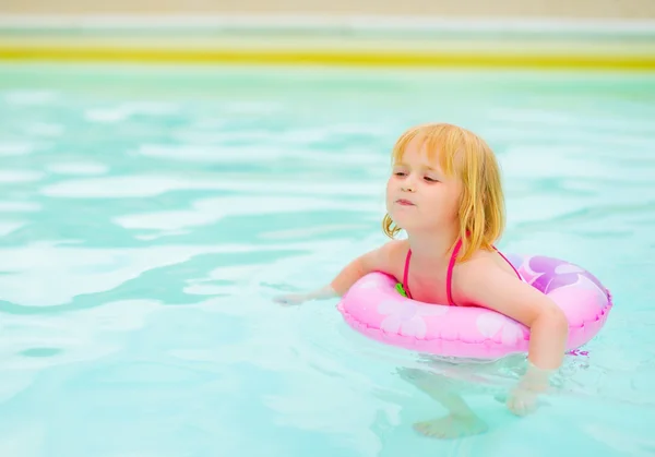 Bébé fille avec anneau de natation dans la piscine — Photo