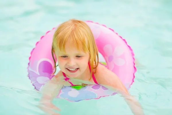 Portrait of baby girl with swim ring swimming in pool — Stock Photo, Image