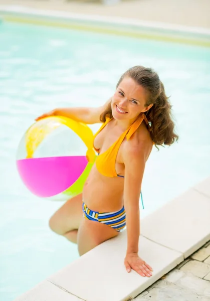 Porträtt av leende ung kvinna med bollen står i simning p — Stockfoto