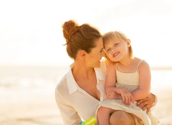 Portrait of happy mother and baby girl on the beach in the eveni Royalty Free Stock Images