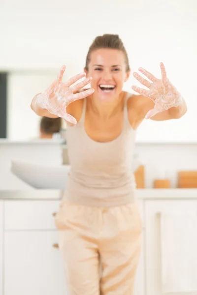 Mutlu genç kadın sabunlu ellerini gösteriyor. — Stok fotoğraf