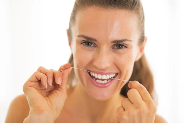 Portrait of young woman using dental floss — Stock Photo, Image
