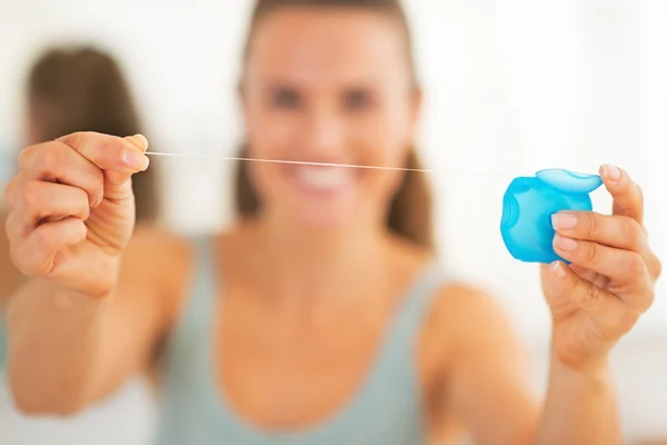 Primo piano su felice giovane donna mostrando filo interdentale — Foto Stock