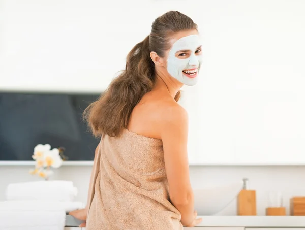 Sorrindo jovem mulher vestindo máscara cosmética facial — Fotografia de Stock