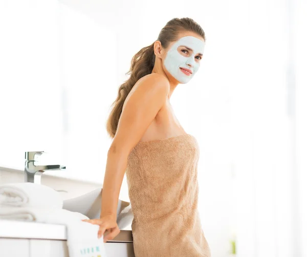 Portret van gelukkige jonge vrouw dragen cosmetische gezichtsmasker — Stockfoto