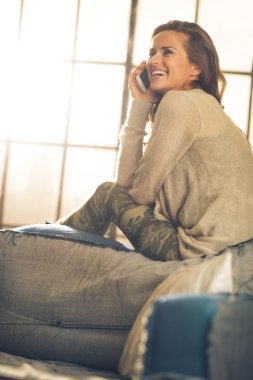 Mutlu genç kadın loft daire cep telefonunda söz