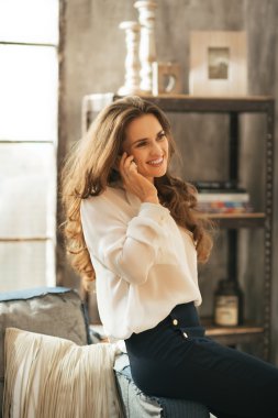 Mutlu genç kadın loft daire cep telefonunda söz