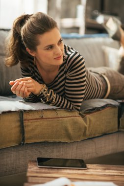 Genç kadın divan loft daire üzerinde döşeme