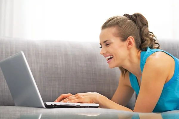 Jovem mulher usando laptop na sala de estar — Fotografia de Stock