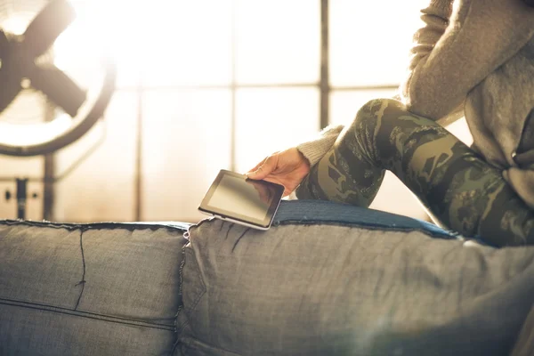 Close up on young woman sitting with tablet pc in loft apartment — стоковое фото