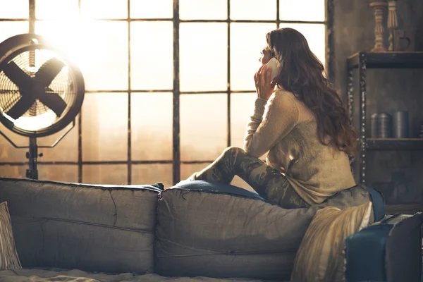 Young woman talking cell phone in loft apartment — Stock Photo, Image