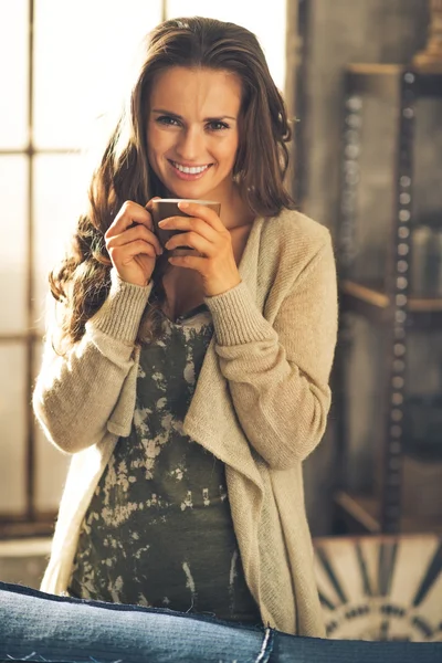 Retrato de una joven sonriente con taza de café en el desván aparte —  Fotos de Stock