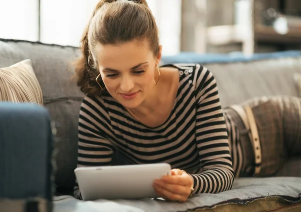 Gelukkig jonge vrouw Bank opleggen en de tablet pc gebruiken — Stockfoto