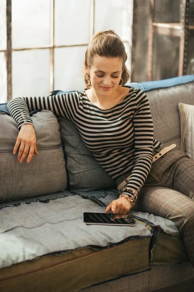 Mujer joven que usa la tableta PC mientras está sentado en el apartamento loft — Foto de Stock