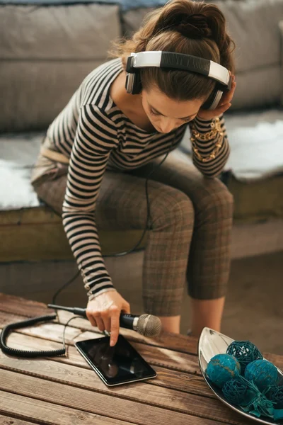 Nuori nainen kuulokkeet mikrofonilla käyttäen tabletti pc — kuvapankkivalokuva