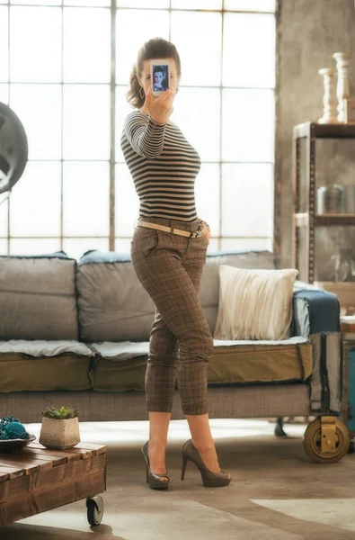 Retrato de comprimento total de jovem mulher fazendo selfie no loft apartm — Fotografia de Stock