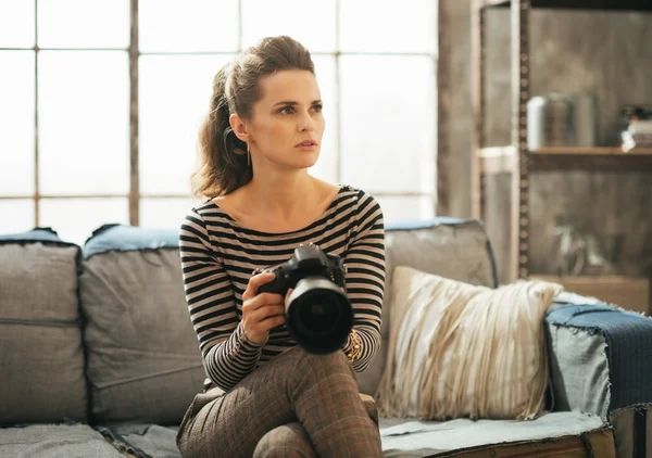 Potret wanita muda dengan kamera foto dslr duduk di loteng — Stok Foto
