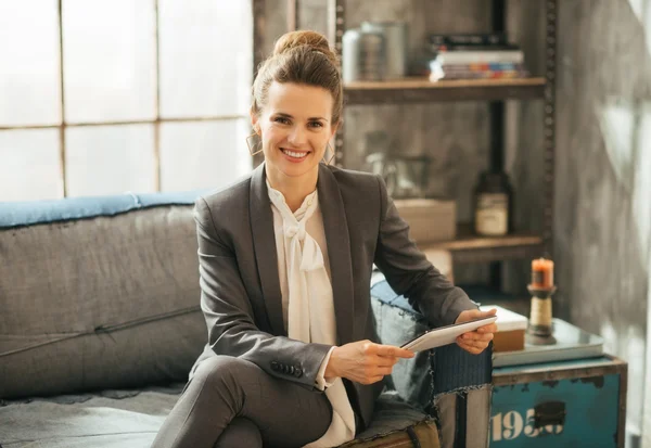 Счастливая бизнес-леди с планшетным компьютером в мансардной квартире — стоковое фото
