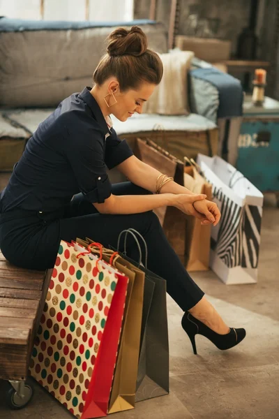 Jonge vrouw met boodschappentassen zitten in Zolder Appartement — Stockfoto