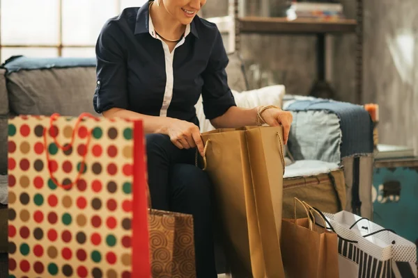 Close-up op gelukkige jonge vrouw met boodschappentassen in loft apartmen — Stockfoto