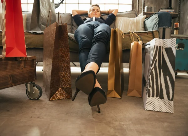 Nahaufnahme einer entspannten jungen Frau mit Einkaufstaschen im Loft-Appartement — Stockfoto