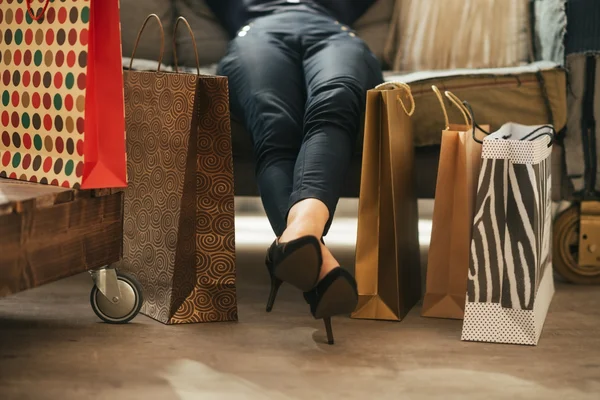 Närbild på avslappnad ung kvinna med shoppingkassar i loft lägenheter — Stockfoto