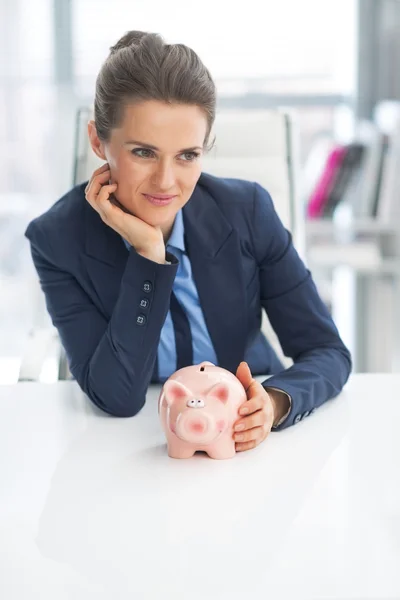Portrait of thoughtful business woman with piggy bank — Stock Photo, Image