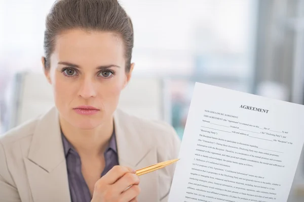 Portrait of business woman pointing on document — Stock Photo, Image