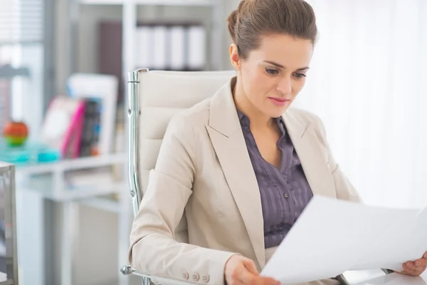 Heureuse femme d'affaires examinant les documents en fonction — Photo