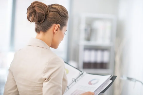 Business woman examining documents in office. rear view — Stock Photo, Image