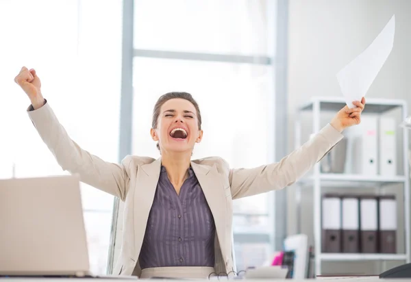 Glückliche Geschäftsfrau mit Urkunde bei der Arbeit — Stockfoto