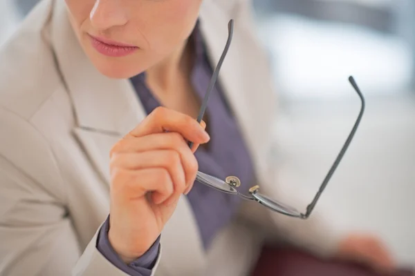 Closeup on business woman holding eyeglasses — Stock Photo, Image