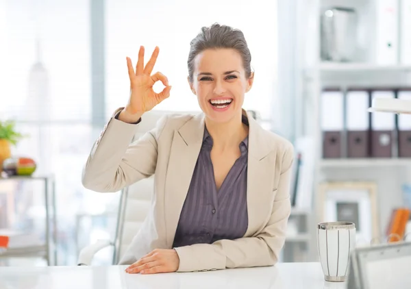 Porträtt av leende business kvinna visar ok gesten i office — Stockfoto