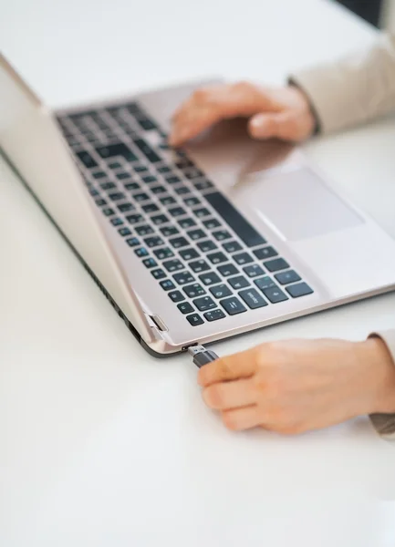 Zakenvrouw plug in usb flash in laptop — Stockfoto