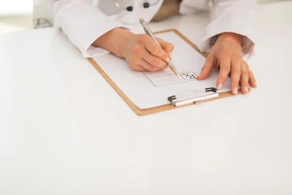 Primer plano de la mujer doctora escribiendo en portapapeles —  Fotos de Stock