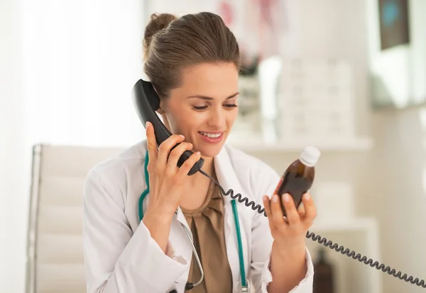 Médecin femme avec bouteille de médicament téléphone parlant — Photo