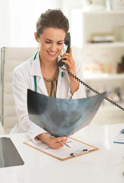 Mujer doctora sonriente con teléfono que habla de fluorografía —  Fotos de Stock